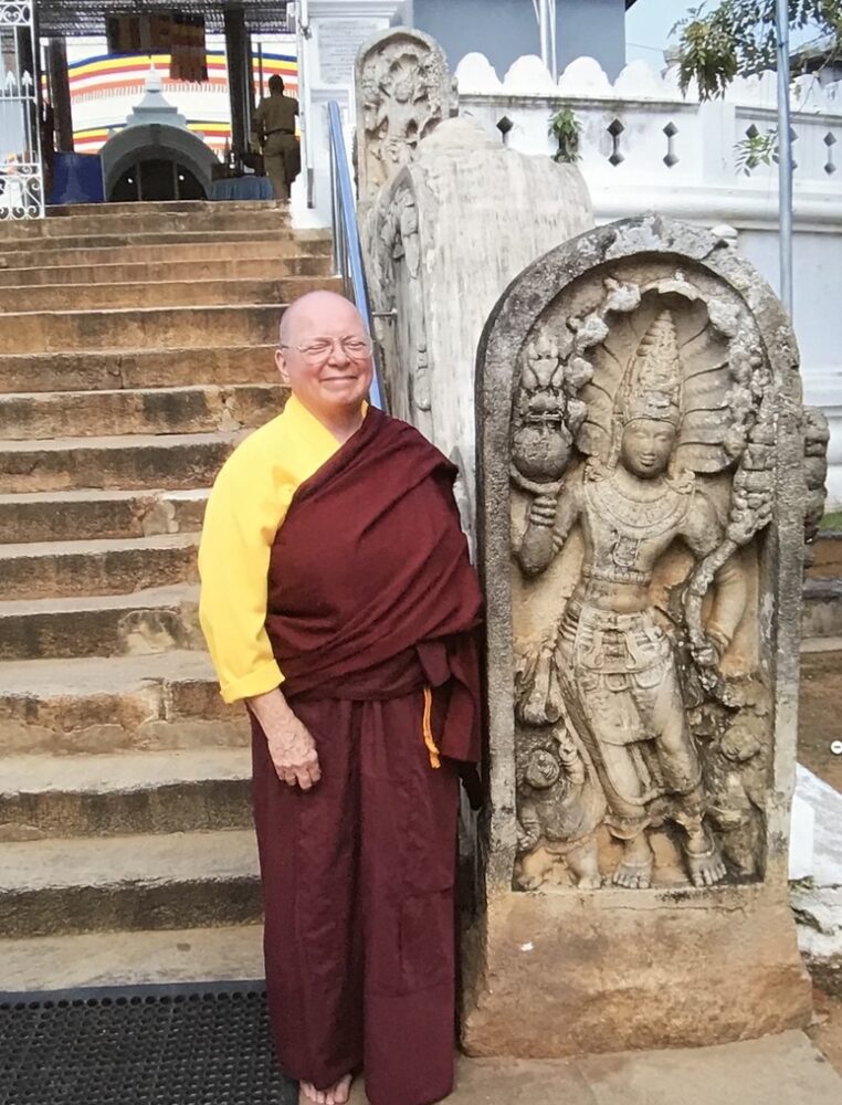 Guardstone with guardian deva, naga around head, and dwarf yakshas at the base in front of the Thuparama Stupa in Anuradhapura, Sri Lanka.