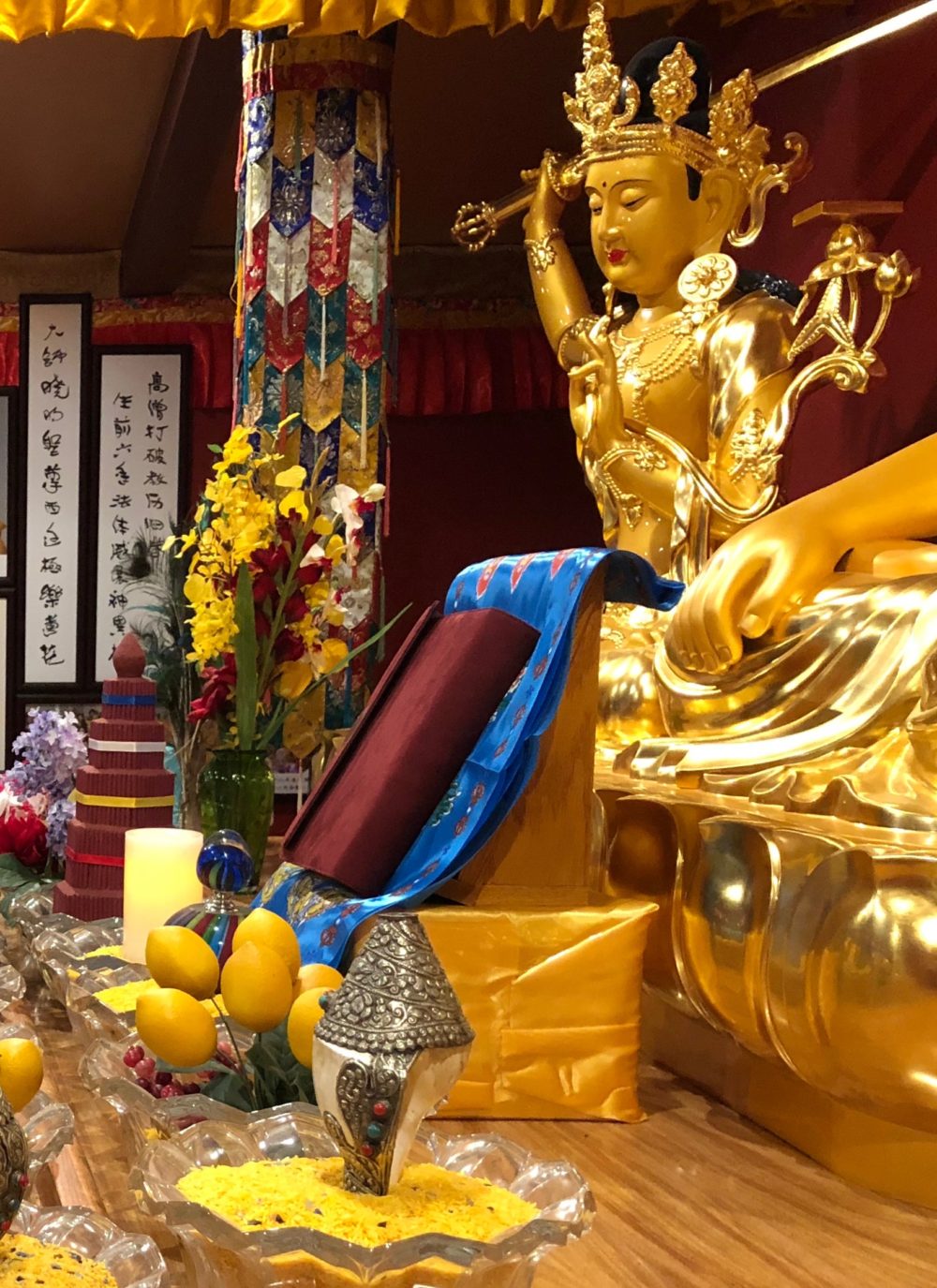 Manjurshri Bodhisattva stands guard over the Chinese edition of ‘Expounding the Absolute Truth Through the Heart Sutra’ on the altar in the Buddha Hall at the Holy Vajrasana Temple.
