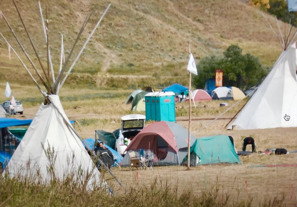 Buddhist camp in back near trees with orange TIbetan door.